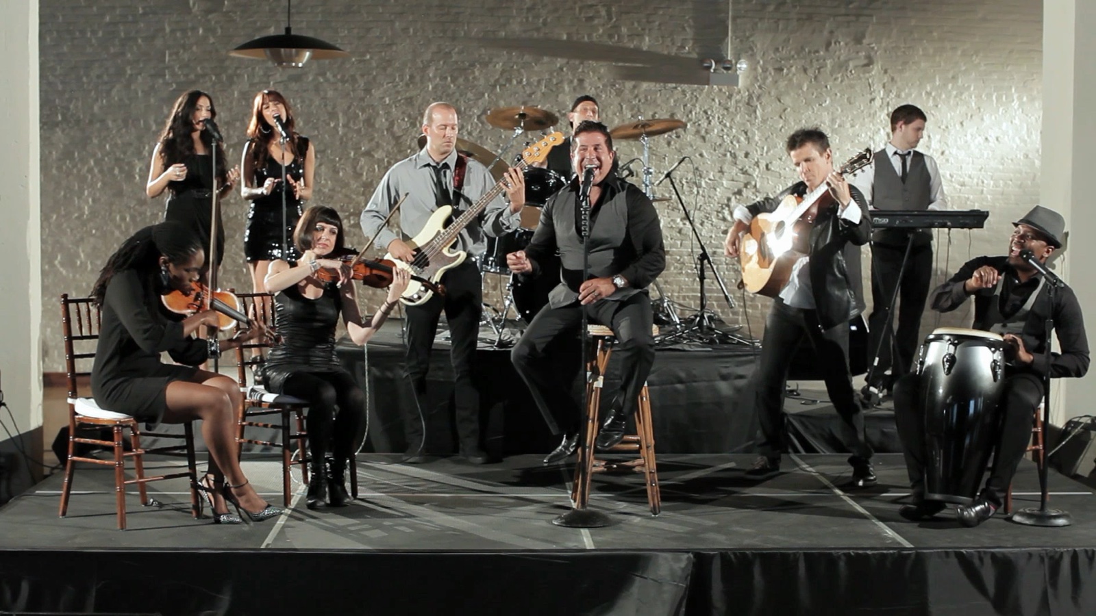 Full band performing, seated string ensemble arrangement